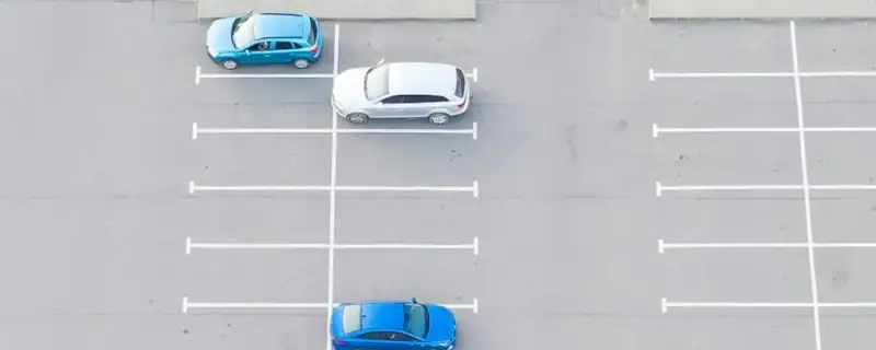 aerial shot of a wide parking lot with parked cars