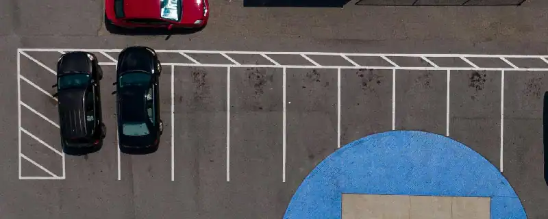 cars parked in a striped parking lot.webp
