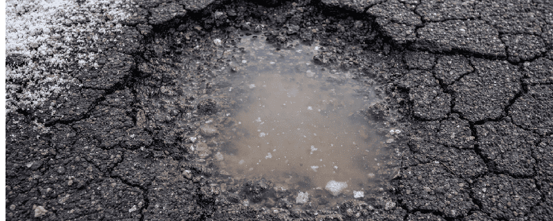 pothole with water in it because of accelerate wear