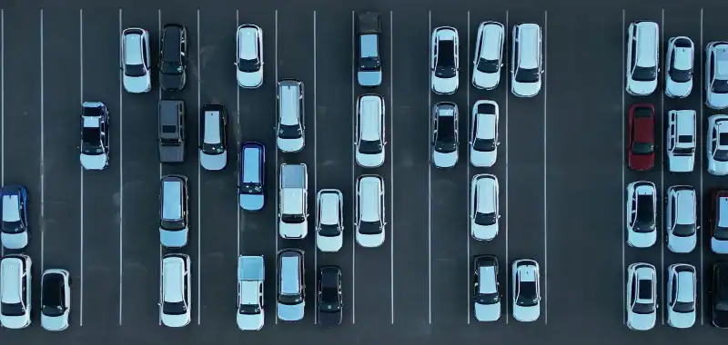 Aerial view of a nearly empty parking lot with cars