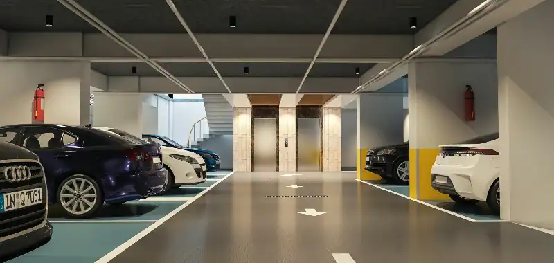 Modern underground parking garage with parked cars and elevators
